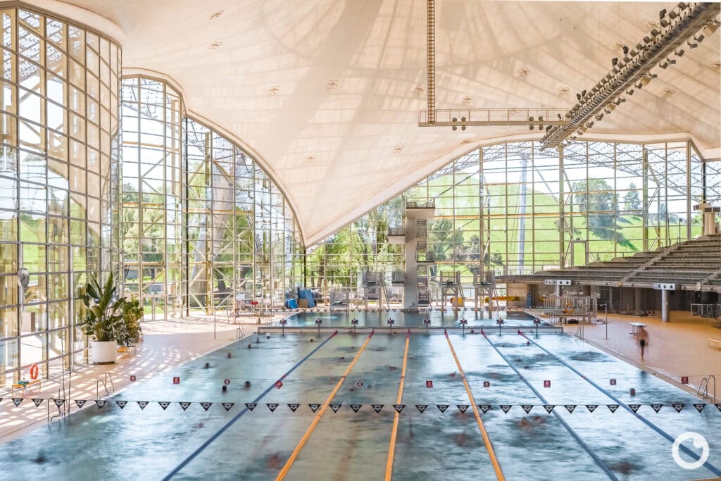 Ansicht des Olympiaschwimmbades mit Zeltdachkonstruktion und Olympiaturm in München, Bauherr Landeshauptstadt München, Architekten Behnisch & Partner, Ingenieure Frei Otto u.a., 1972. Foto: Bertrand Weiss, weissfotografie.com