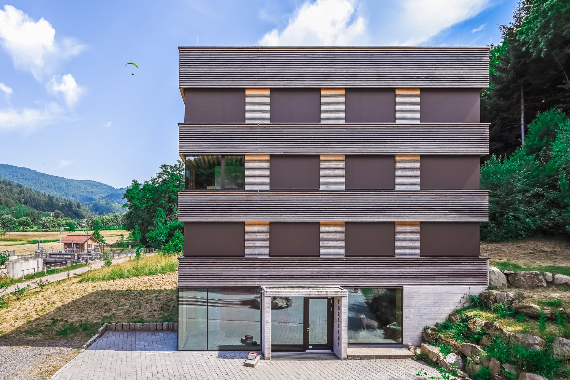 Frontalansicht des Forstamts Freiburg mit horizontal gegliederter Holzfassade. Architektur von Stocker Dewes Architekten BDA. Foto: Bertrand Weiss, weissfotografie.com.