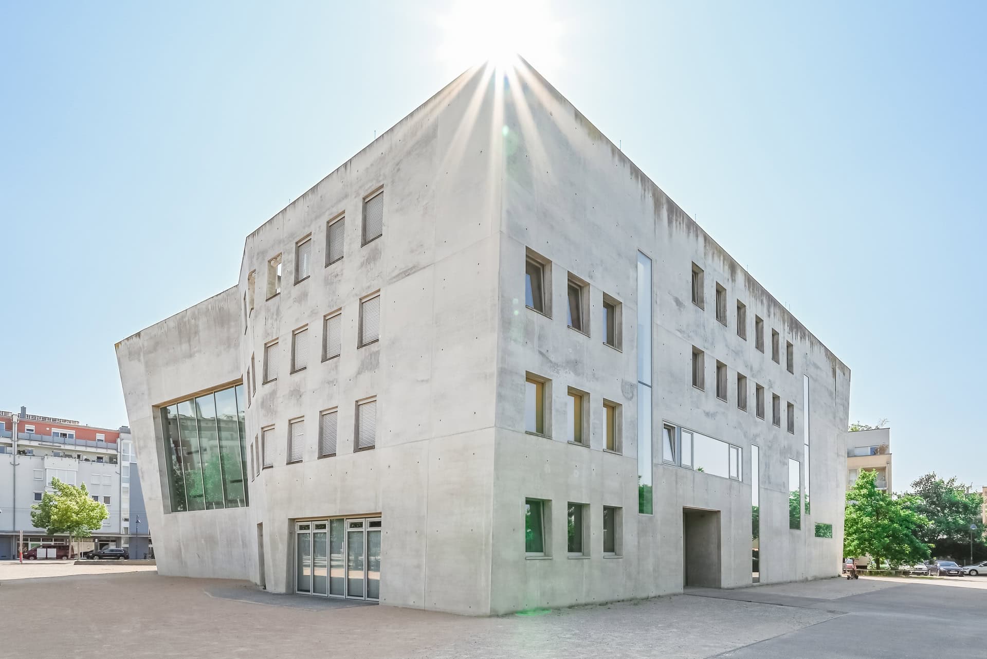 Maria-Magdalena-Kirche im Gegenlicht mit plastischer Sichtbetonfassade und klar gesetzten Öffnungen. Architektur von Kister Scheithauer Gross. Foto: Bertrand Weiss, weissfotografie.com.