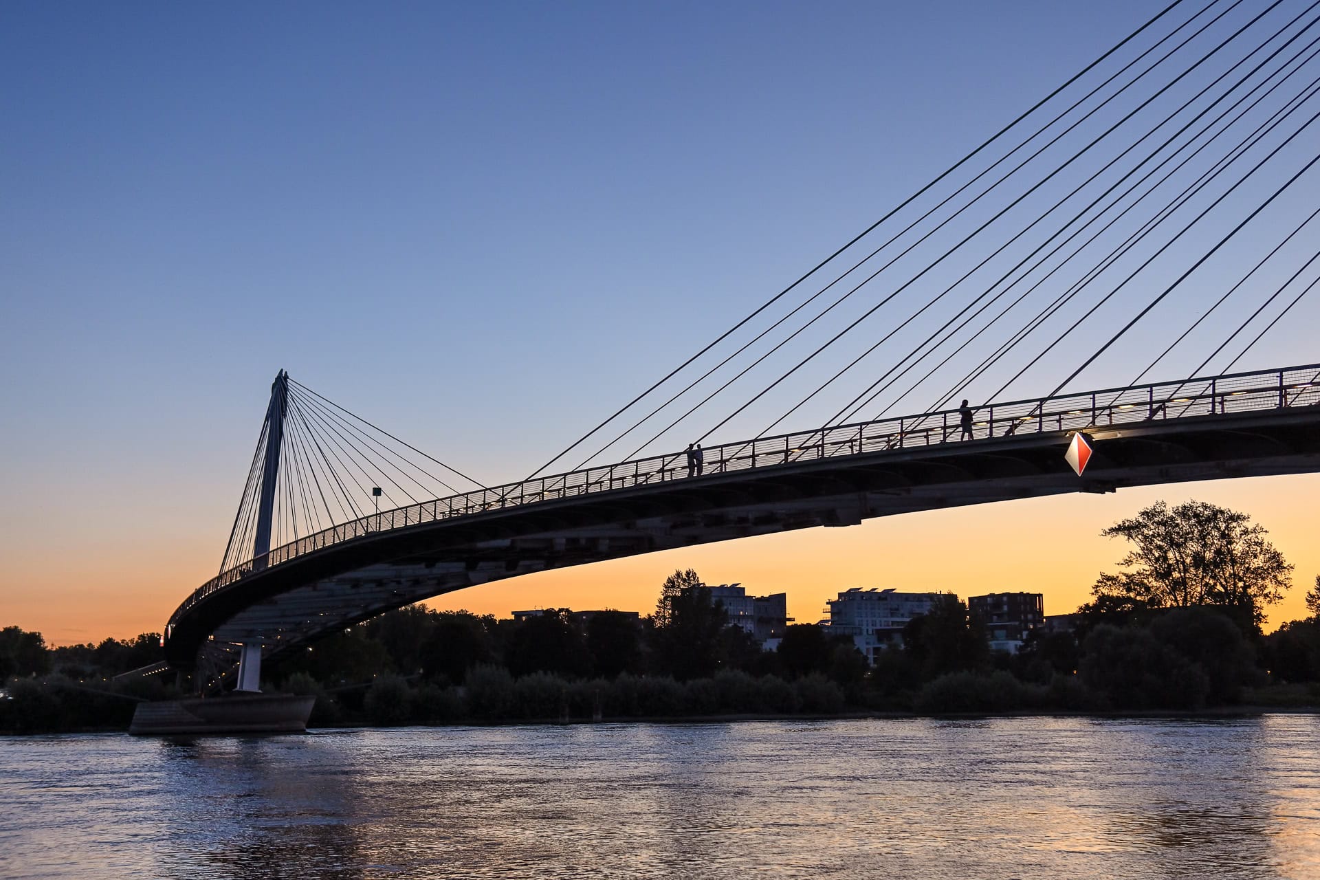 Seitliche Ansicht der Passerelle des Deux Rives über dem Rhein bei Sonnenuntergang. Architektur von Marc Mimram Architecture & Ingénierie. Foto: Bertrand Weiss, weissfotografie.com.