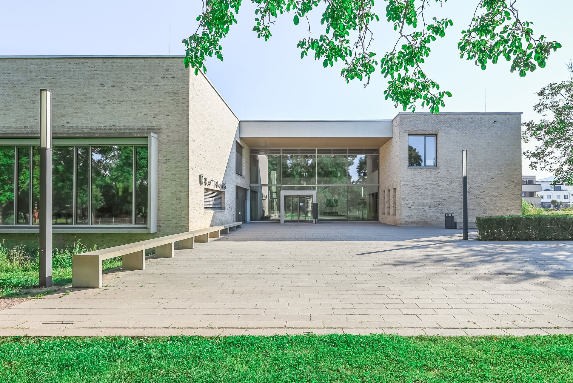 Eingangsbereich des Neuen Rathauses Schallstadt mit hellem Klinker, Glasfassade und Vorplatz. Architektur von OHO Architekten. Foto: Bertrand Weiss, weissfotografie.com.