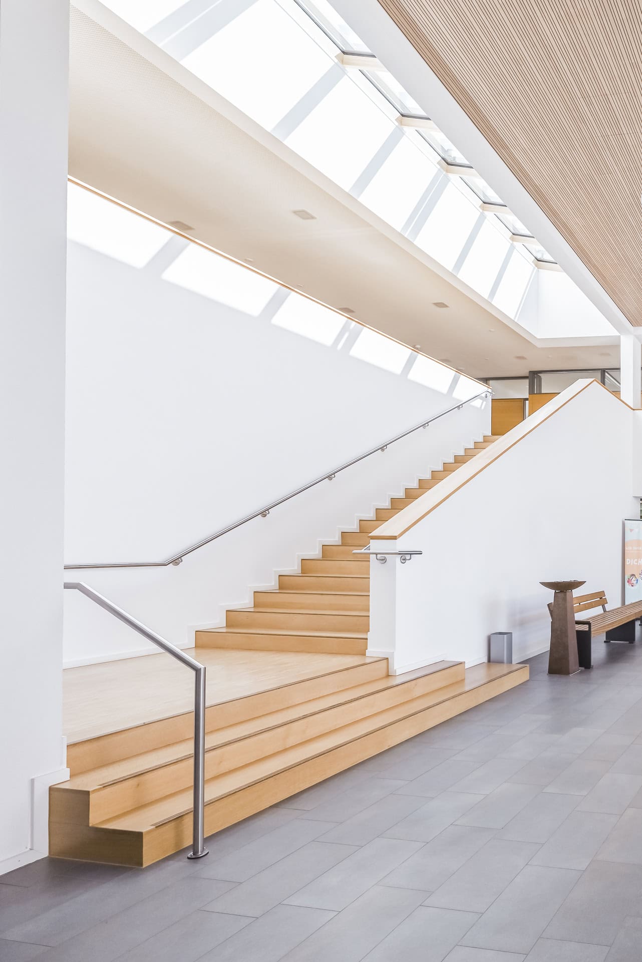 Treppenraum im Neuen Rathaus Schallstadt mit Holzstufen, Oberlicht und feinem Schattenspiel. Architektur von OHO Architekten. Foto: Bertrand Weiss, weissfotografie.com.
