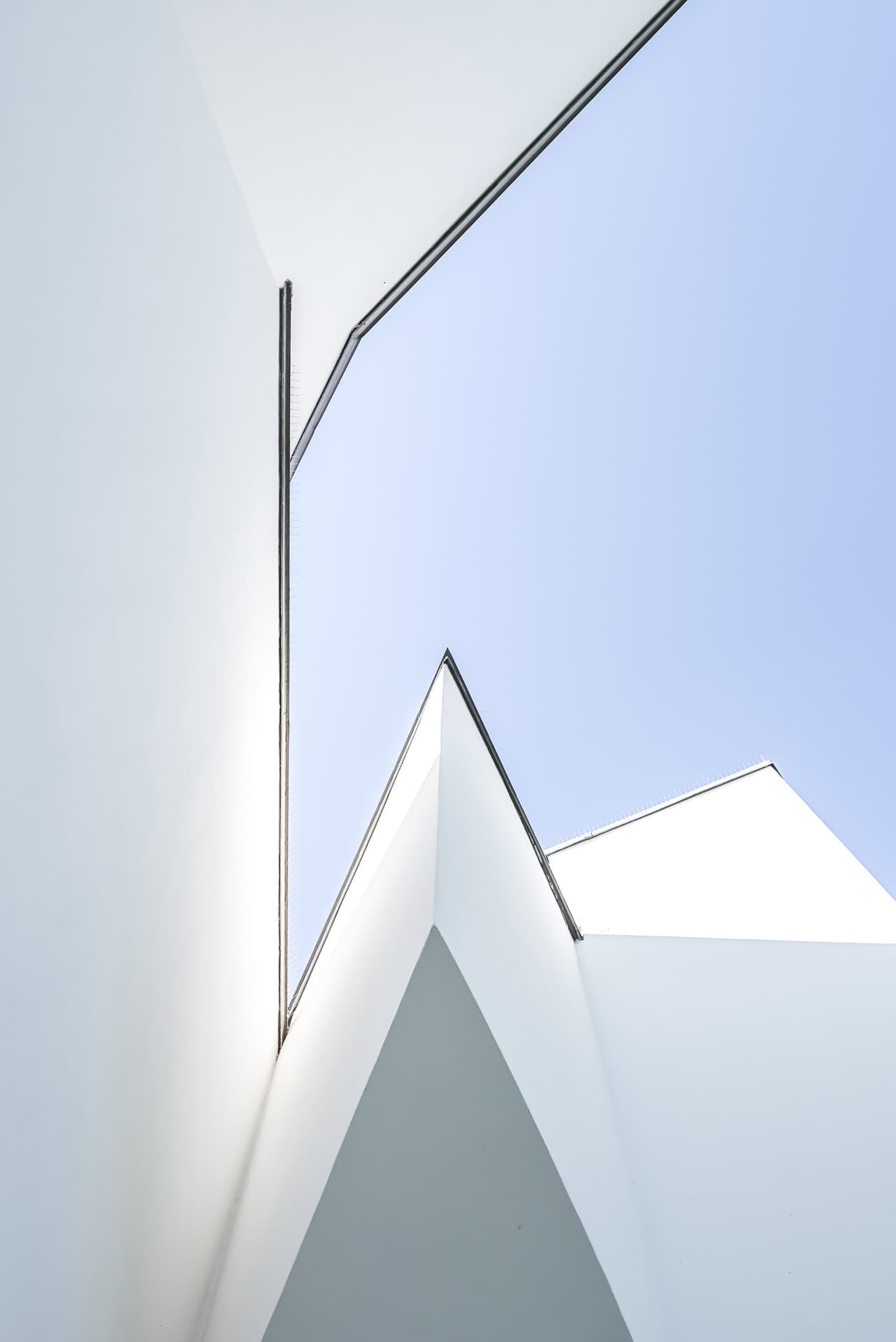 Abstrakte Fassadendetails des Vitra Design Museums mit weißen Flächen, Dachkanten und blauem Himmel. Architektur von Frank O. Gehry. Foto: Bertrand Weiss, weissfotografie.com.