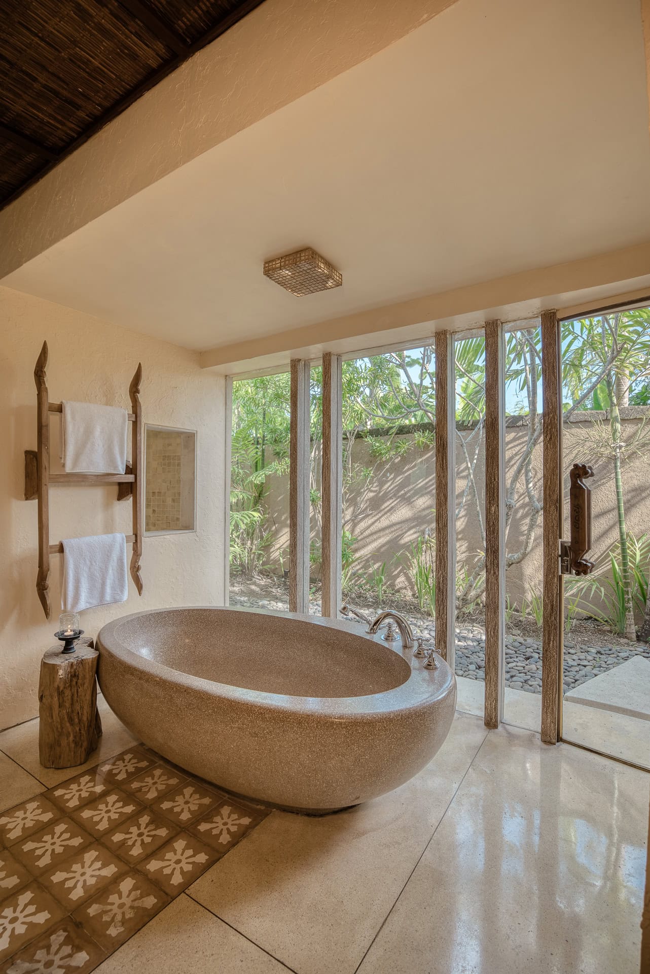 Badezimmer mit freistehender Badewanne und bodentiefem Blick in einen privaten Gartenhof. Architektur von I Ketut Siandana. Foto: Bertrand Weiss, weissfotografie.com.
