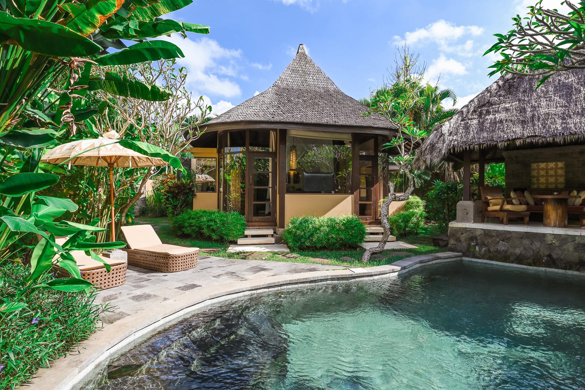 Villa mit privatem Pool, Reetdach und üppiger tropischer Bepflanzung. Architektur von I Ketut Siandana. Foto: Bertrand Weiss, weissfotografie.com.