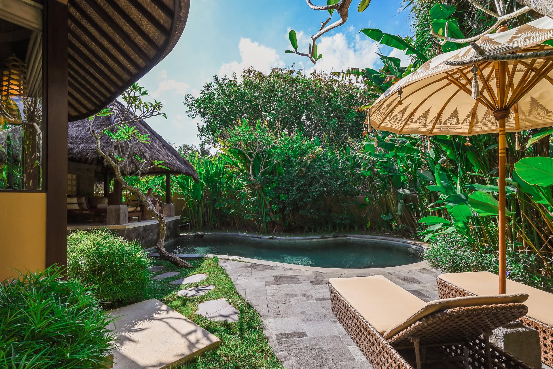 Privater Außenbereich mit Pool, Liegen und traditionellem Sonnenschirm. Architektur von I Ketut Siandana. Foto: Bertrand Weiss, weissfotografie.com.