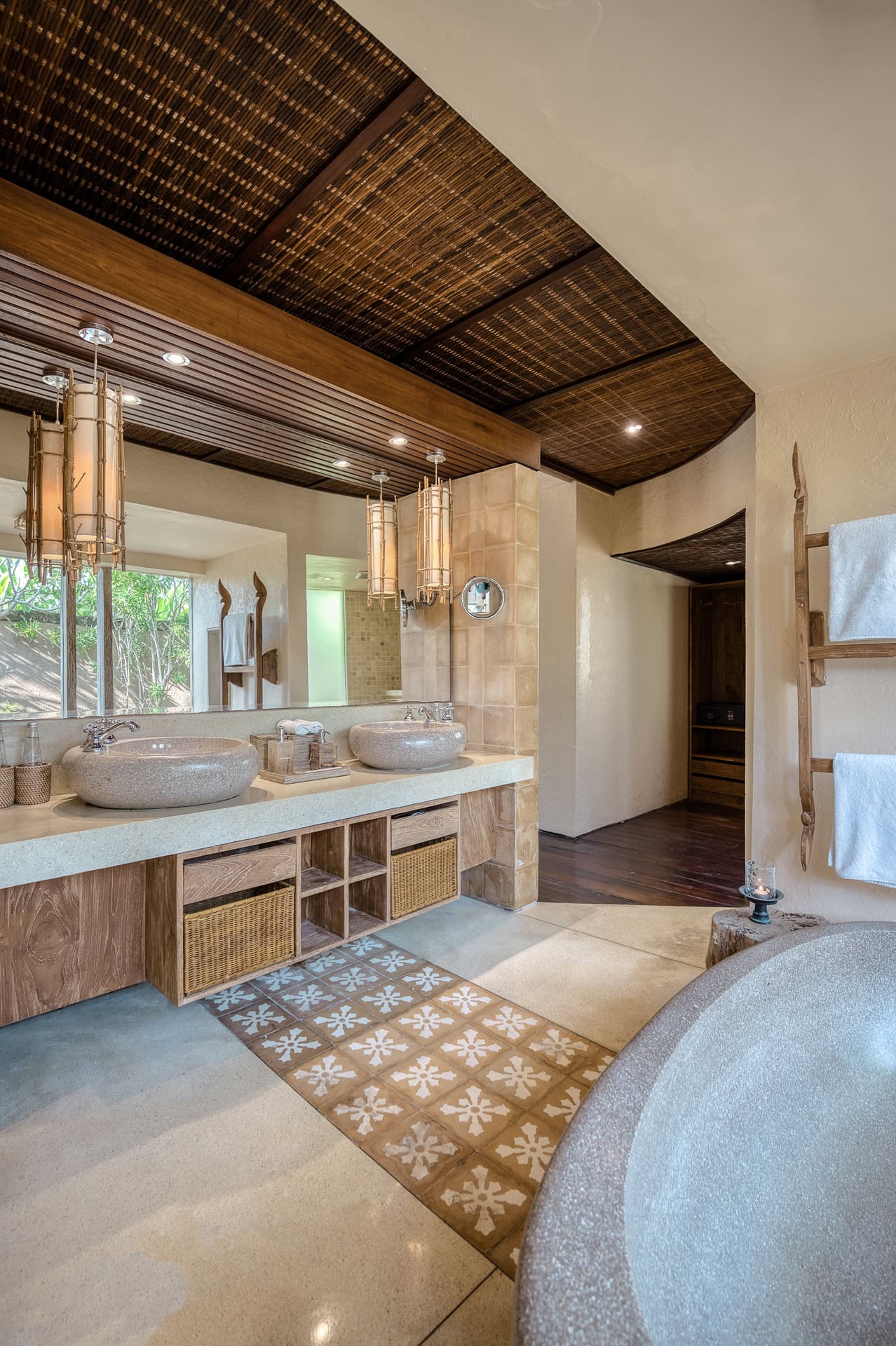 Badezimmer mit Natursteinbecken, Holz, Flechtwerk und warmem Tageslicht. Architektur von I Ketut Siandana. Foto: Bertrand Weiss, weissfotografie.com.