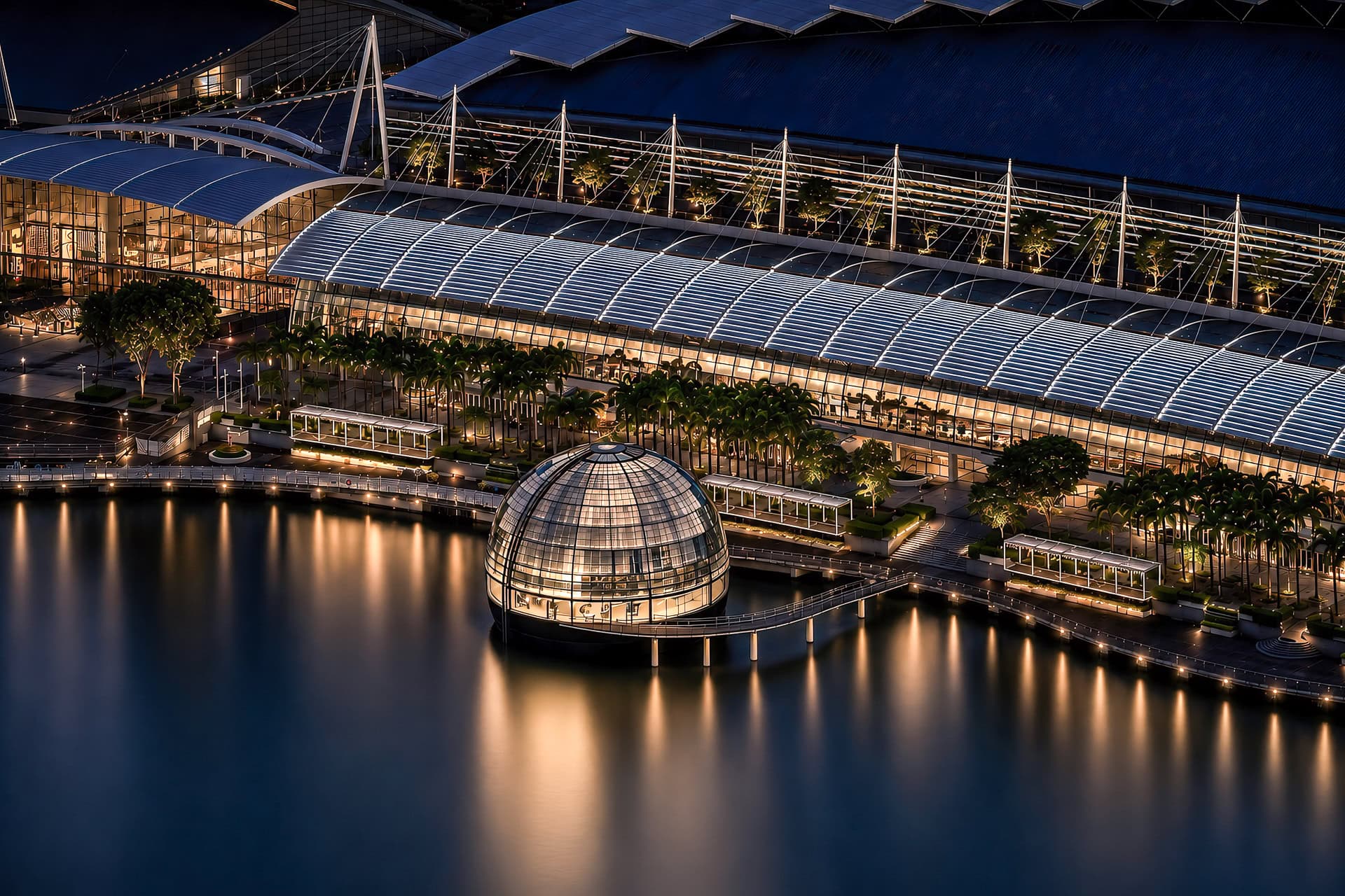 Nächtliche Ansicht des Apple Marina Bay Sands mit leuchtender Kuppel, Skyline und Spiegelungen auf der Marina Bay. Architektur von Foster + Partners. Foto: Bertrand Weiss, weissfotografie.com.
