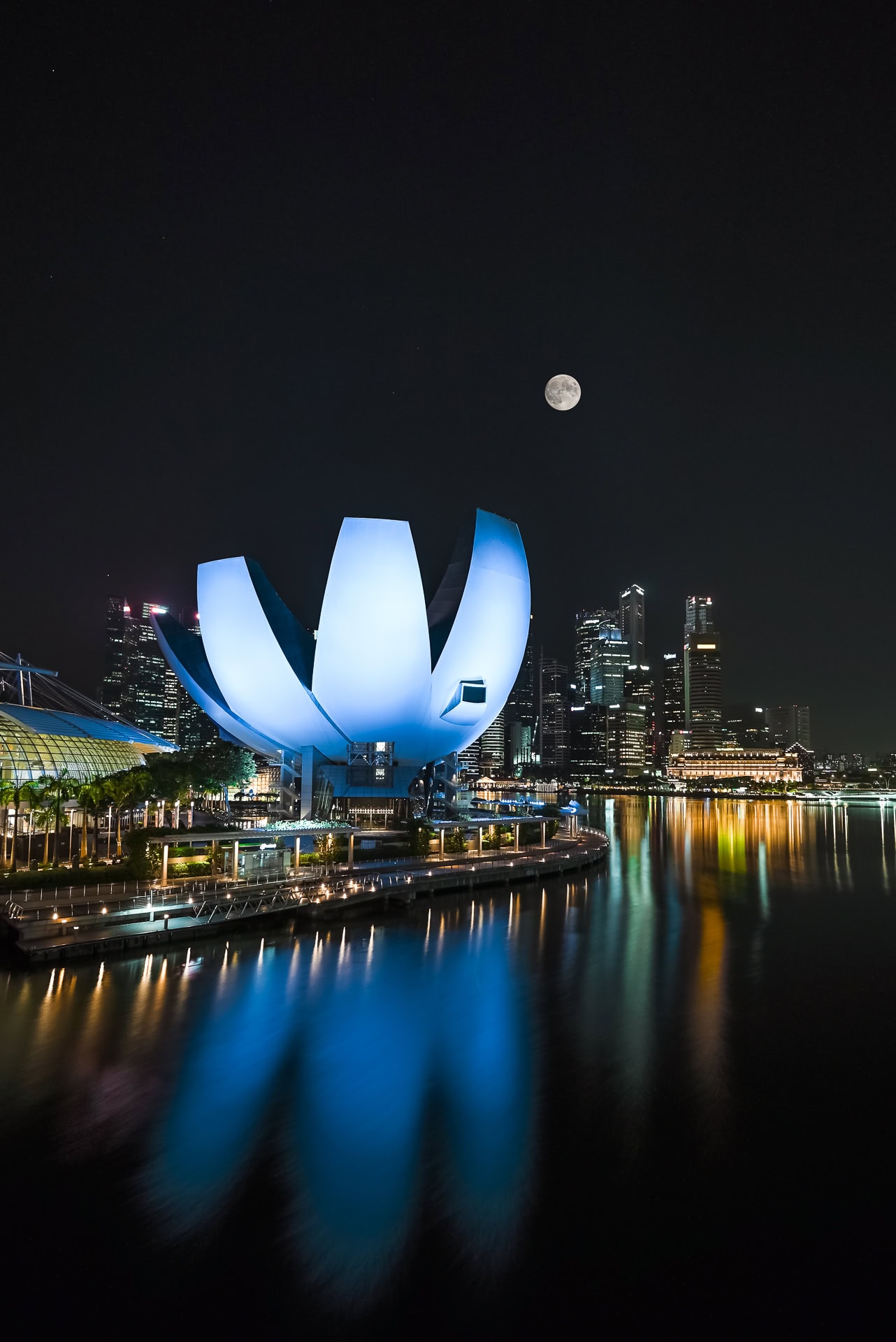 Nächtliche Ansicht der Marina Bay mit ArtScience Museum und Spiegelungen im Wasser. Architektur von Safdie Architects. Foto: Bertrand Weiss, weissfotografie.com.