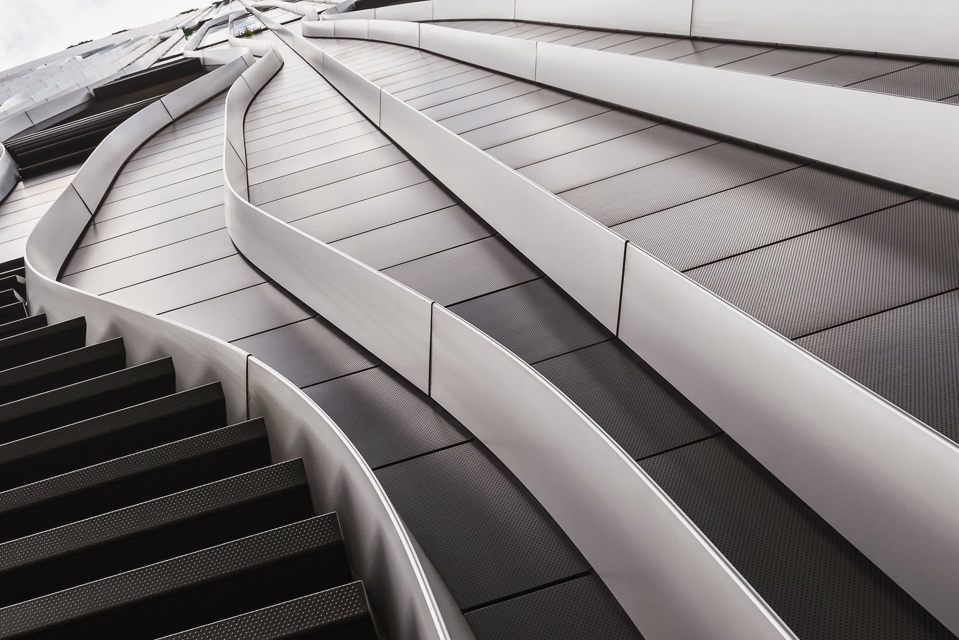 Nahaufnahme der metallischen Fassadenelemente mit weich geschwungenen Linien und perforierten Flächen. Architektur von BIG und CRA. Foto: Bertrand Weiss, weissfotografie.com.