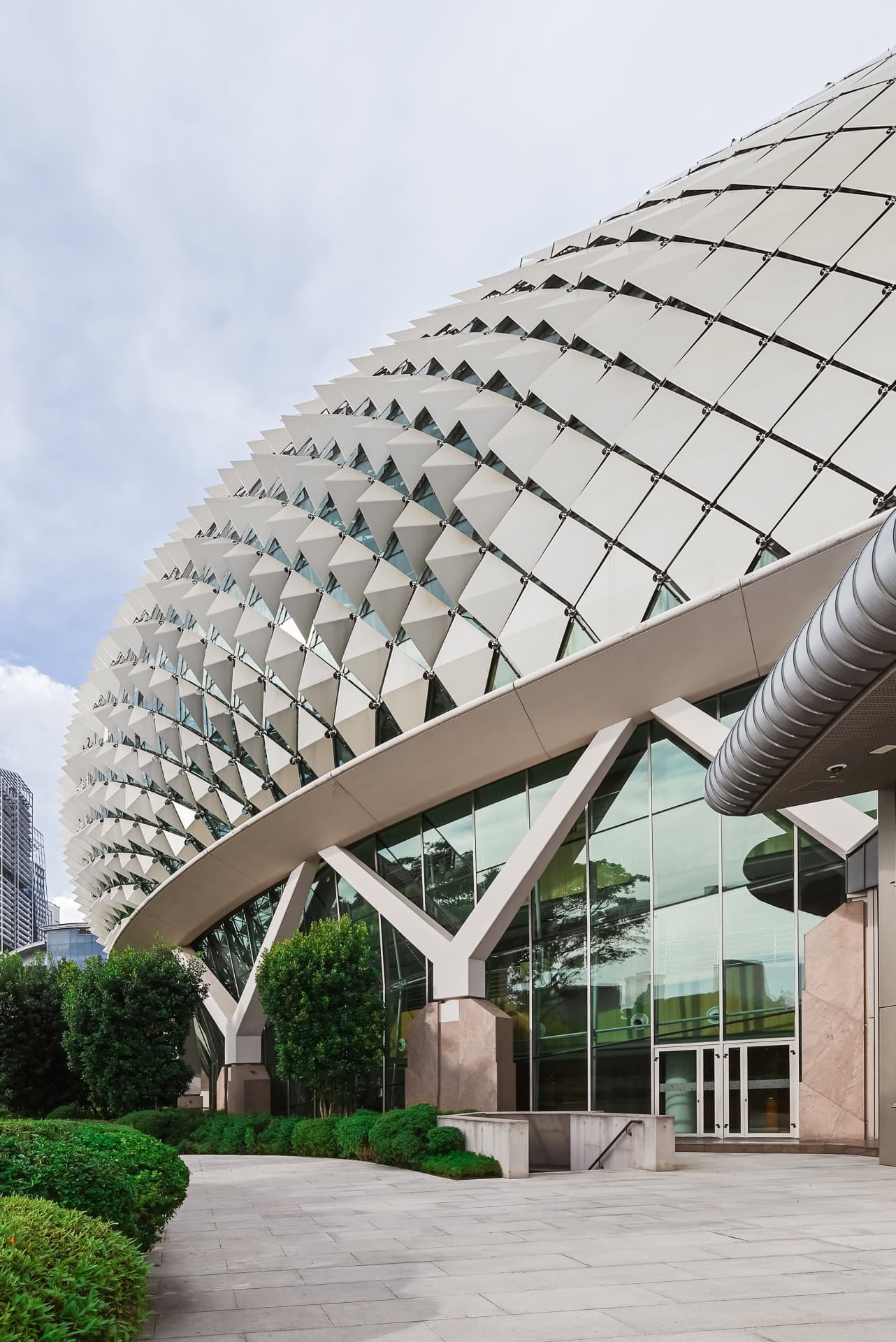 Geschwungener Baukörper des Esplanade mit dreidimensionaler Fassadenstruktur und bepflanzter Außenanlage. Architektur von DP Architects und Michael Wilford & Partners. Foto: Bertrand Weiss, weissfotografie.com.