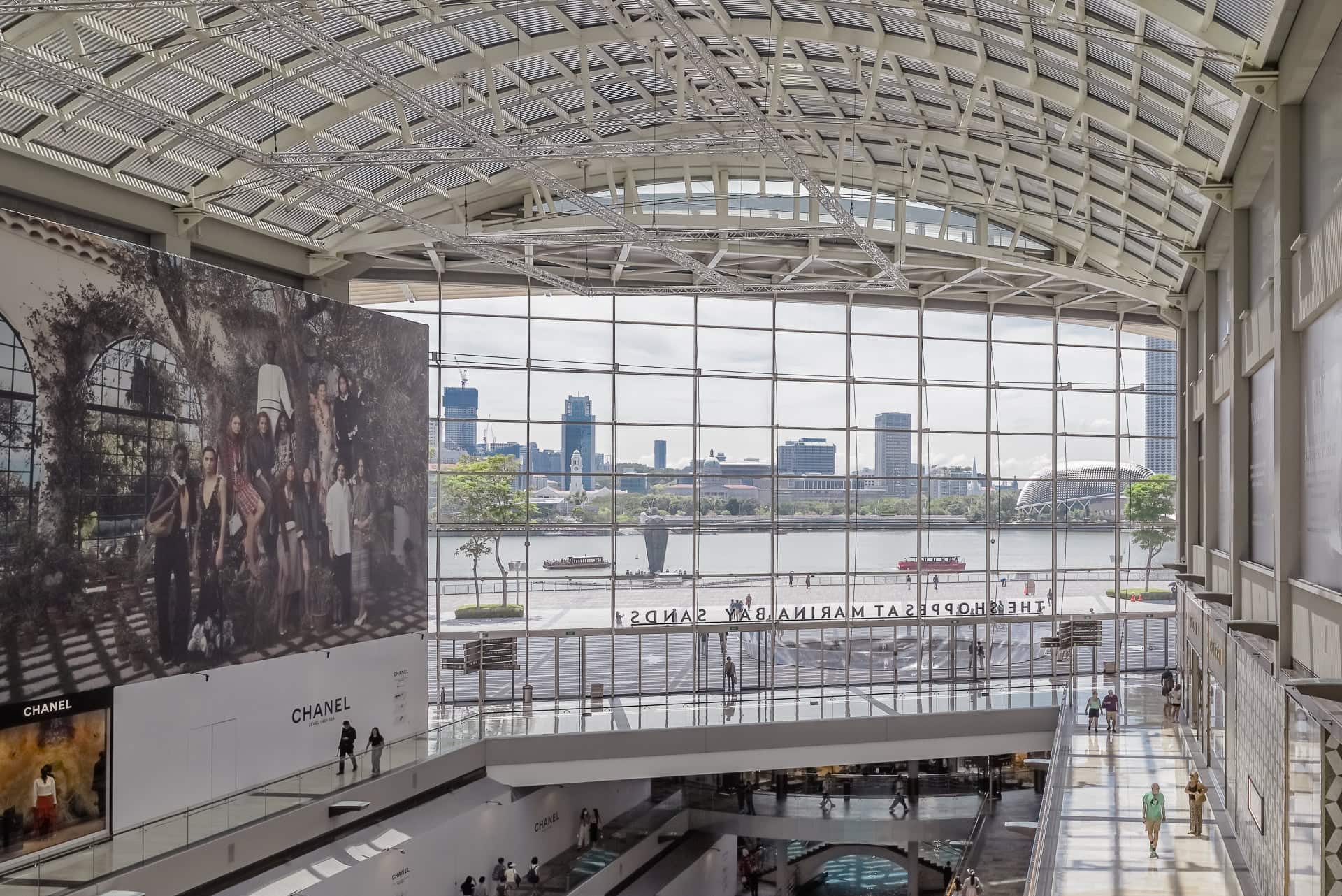 Großzügige Innenhalle mit Glasdach, Stahltragwerk und Blick über die Marina Bay. Architektur von Safdie Architects. Foto: Bertrand Weiss, weissfotografie.com.